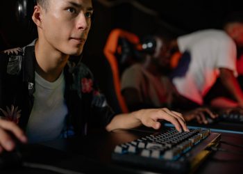 Young adults playing in a competitive esports tournament, deeply focused on gaming.